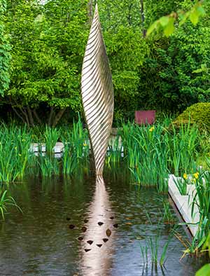 Nyneve large and striking outdoor art arising powerfully out of a pond