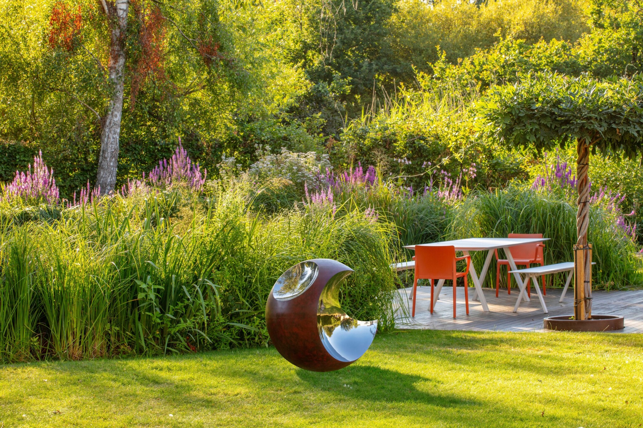 Sphere sculpture in a landscaped garden.