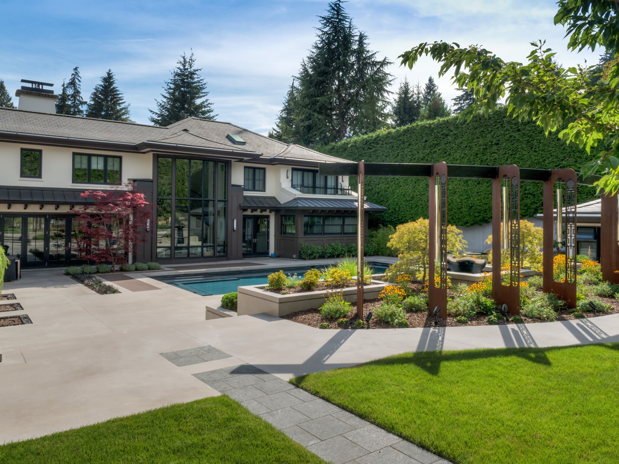 A formal garden with large oxidised steel windchimes as a central focal point
