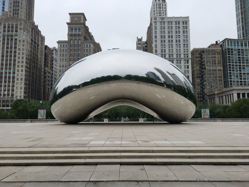 The Cloud Gate sculpture in Chicago’s Millennium Park, with tall buildings in the background.