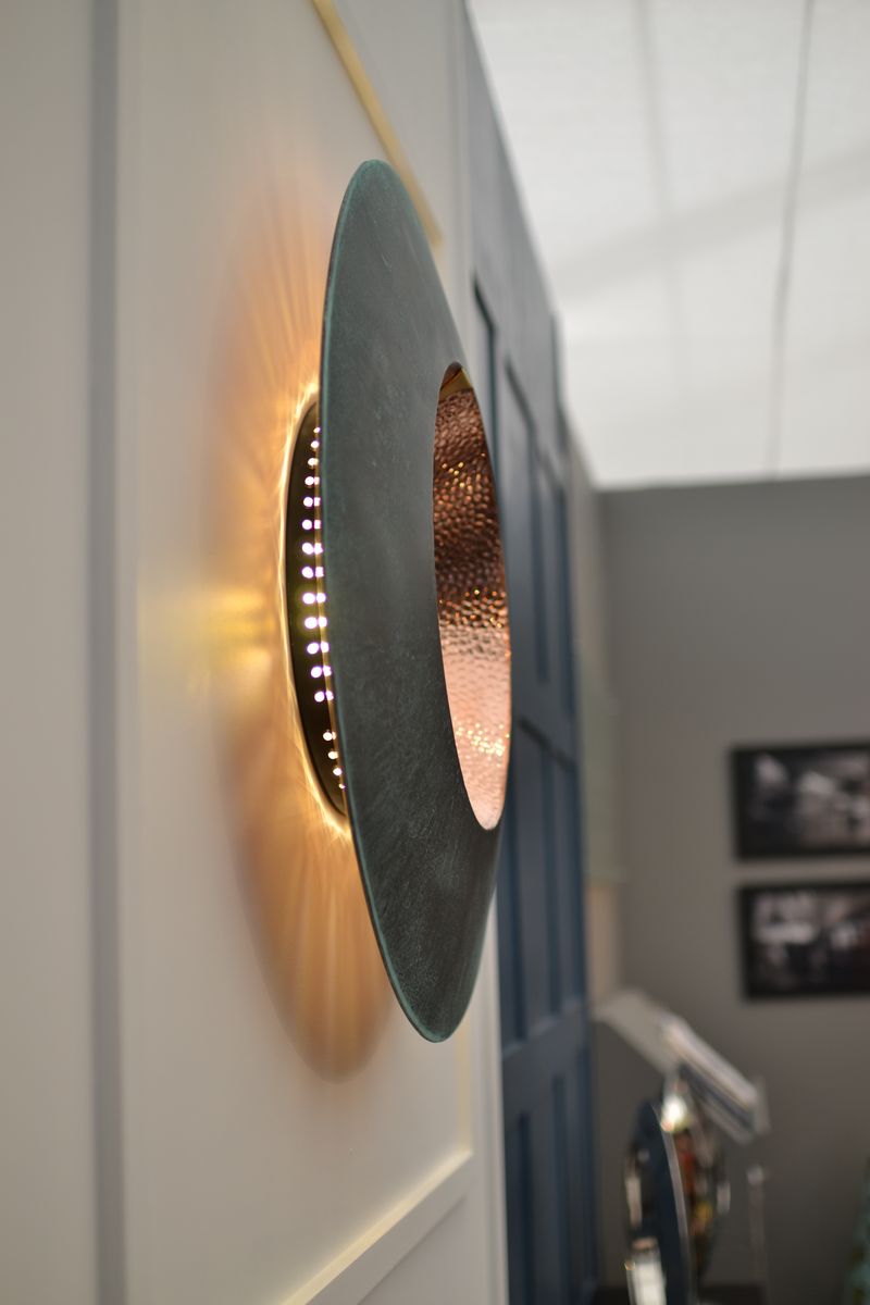 Wall-mounted modern light fitting with a circular metallic design, perfect for corridor sculpture ideas and warm, glowing light.