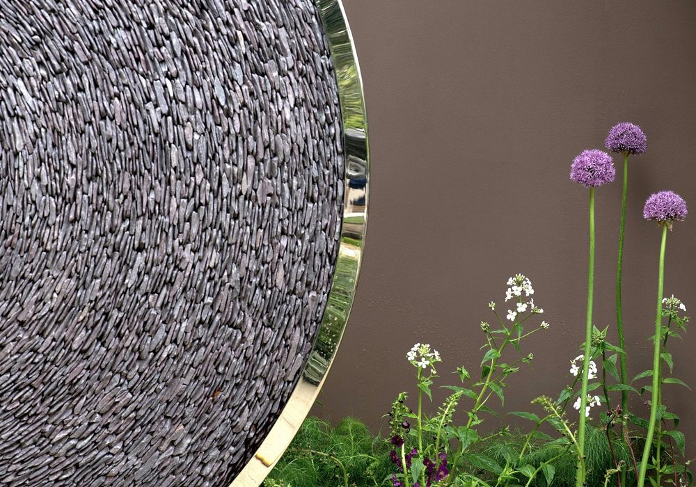 decorative landscape sculpture made from curved metal filled with natural stone