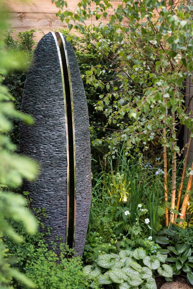 Tall, oval stone sculpture with a central metal strip for that perfect courtyard garden idea